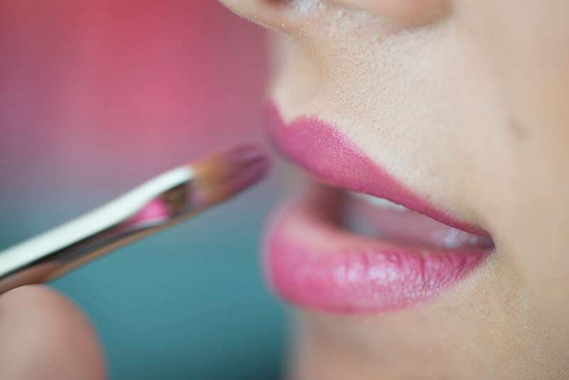 Applicazione labbra fucsia, dettaglio pennello make-up
