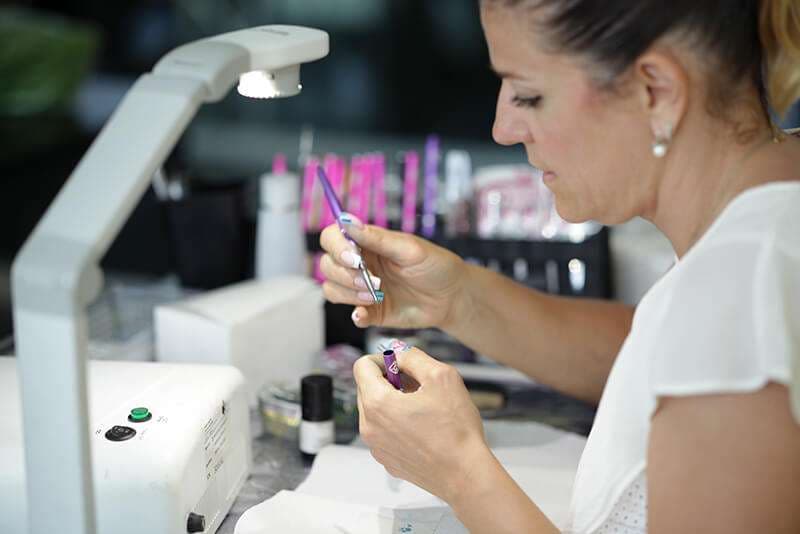 Docente AreaDomani al lavoro con lampada UV durante il corso Nail Art